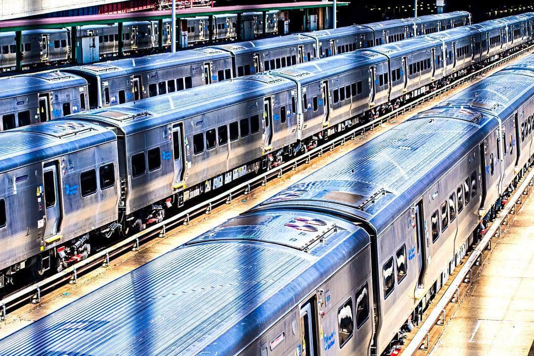 Trenes de cercanías alineados en una playa de vías, vistos desde arriba, con los colores muy saturados.