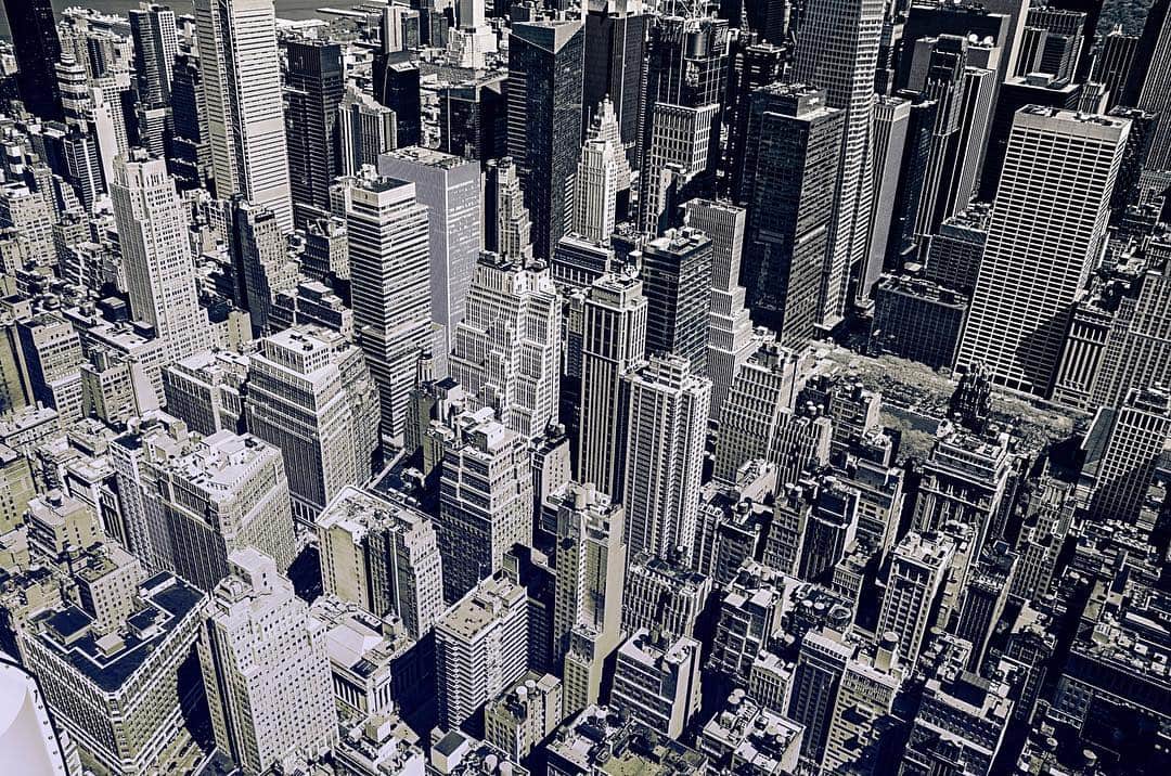 Vista cenital de los rascacielos de Nueva York, muy apiñados, en tonos grises y lilas.