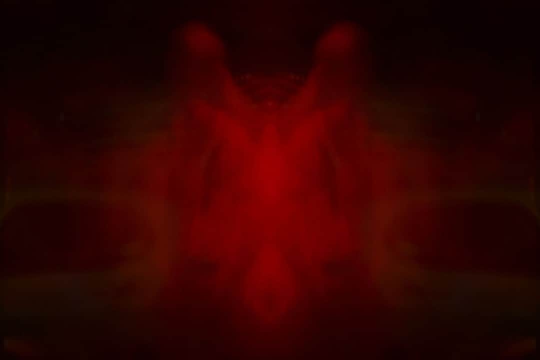 Mancha roja simétrica sobre fondo negro, con forma de test de Rorschach.