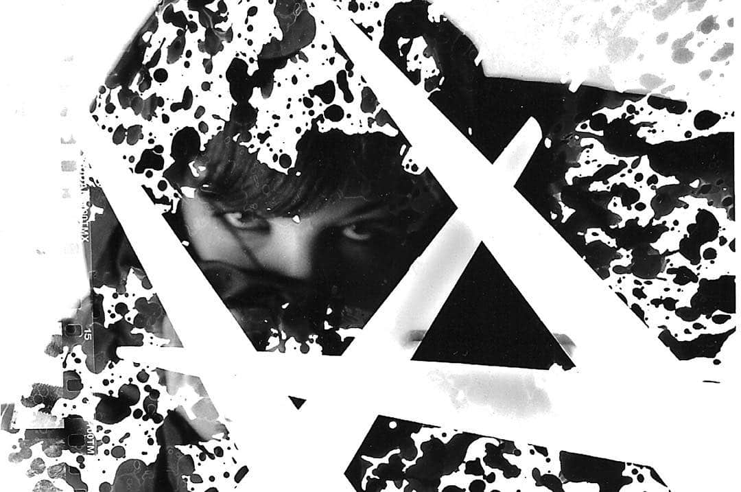 Composición en blanco y negro de alto contraste: un rostro de mujer entre manchas y trazos geométricos.