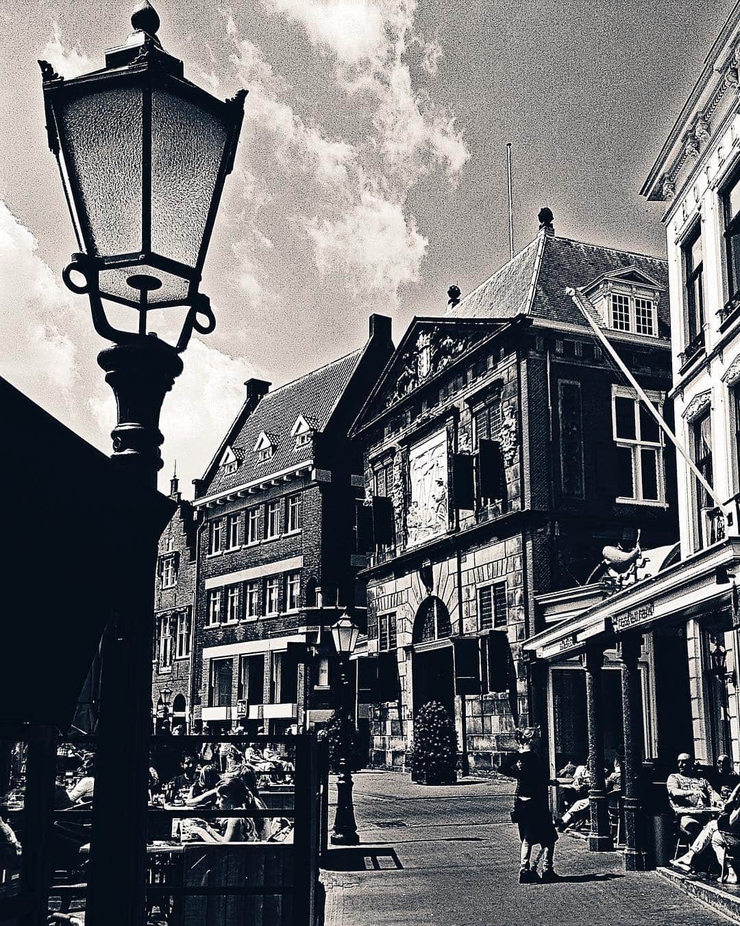 Calle de Utrecht en blanco y negro, con una farola en primer plano y fachadas escalonadas al fondo.