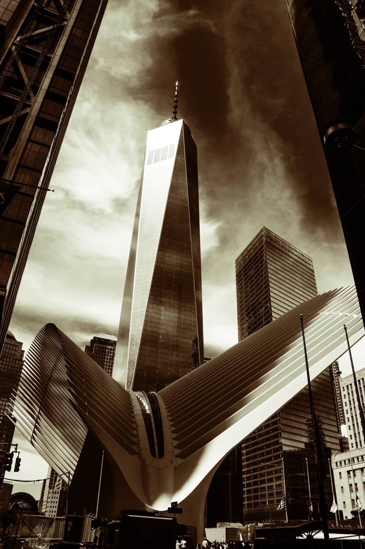 El One World Trade Center en contrapicado, con su antena, sobre las nervaduras blancas del Oculus, virado en tonos sepia.